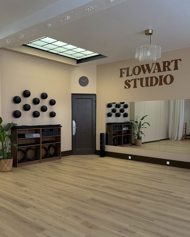 Studio FlowArt à Roubaix — grande salle lumineuse avec miroir et logo mural